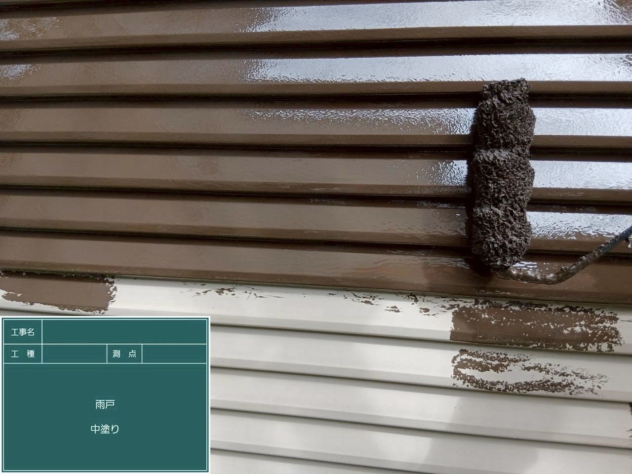 茶色の塗料で中塗り作業している雨戸